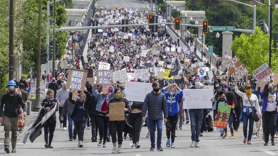 Crowds of protesters walk across the Monroe Street Bridge and up the hill to the Spokane County Courthouse, Sunday, May 31, 2020, in Spokane, Wash. during a protest to express anger over the death of George Floyd in Minneapolis. (Jesse Tinsley/The Spokesman-Review via AP)