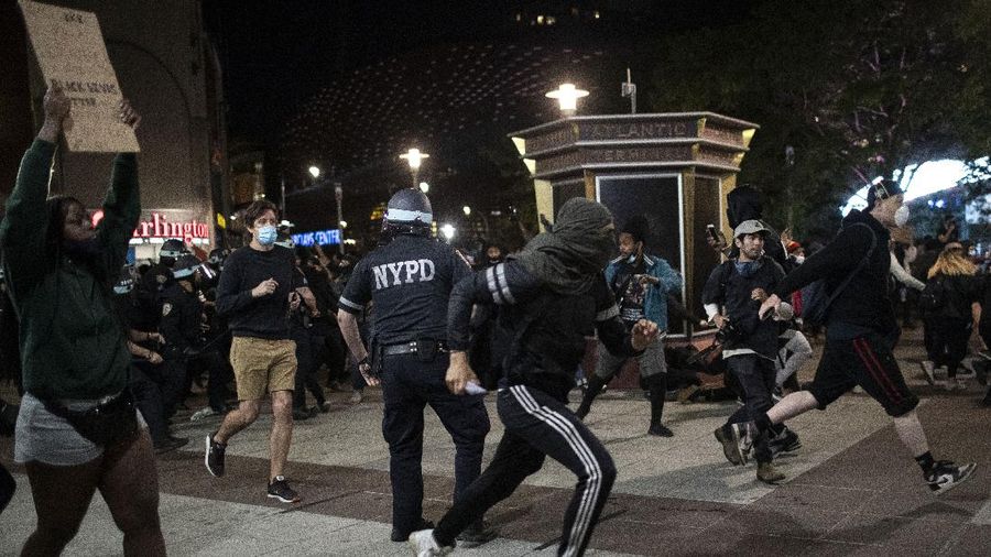 Protesters run from police during a rally for George Floyd, Sunday, May 31, 2020, in the Brooklyn borough of New York. Protests were held throughout the city over the death of Floyd, a black man in police custody in Minneapolis who died after being restrained by police officers on Memorial Day. (AP Photo/Wong Maye-E)