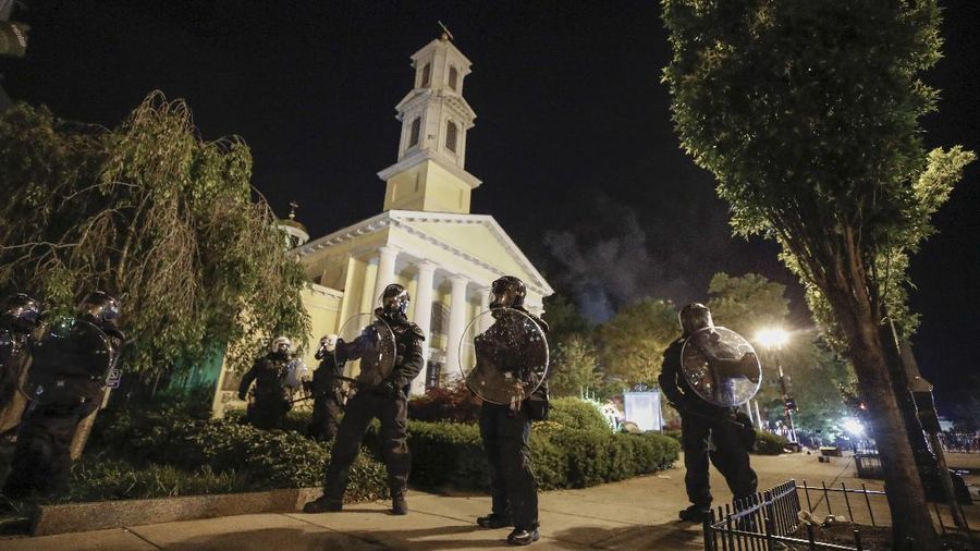 Police stand on H Street as demonstrators protest the death of George Floyd, Sunday, May 31, 2020, near the White House in Washington. Floyd died after being restrained by Minneapolis police officers (AP Photo/Alex Brandon)