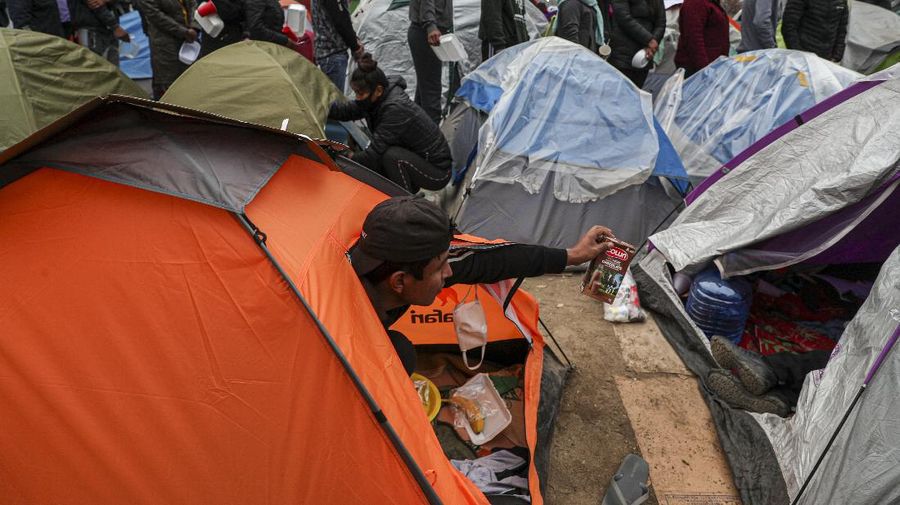 Para pekerja migran asal Peru membangun tenda di luar gedung konsulat Peru untuk menuntut repatriasi di tengah pandemi COVID-19 di Santiago, Chili. AP/Esteban Felix