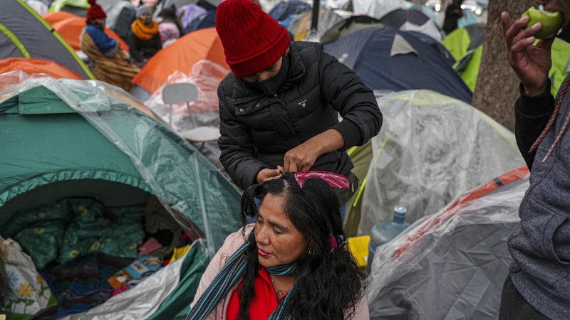 Para pekerja migran asal Peru membangun tenda di luar gedung konsulat Peru untuk menuntut repatriasi di tengah pandemi COVID-19 di Santiago, Chili. AP/Esteban Felix