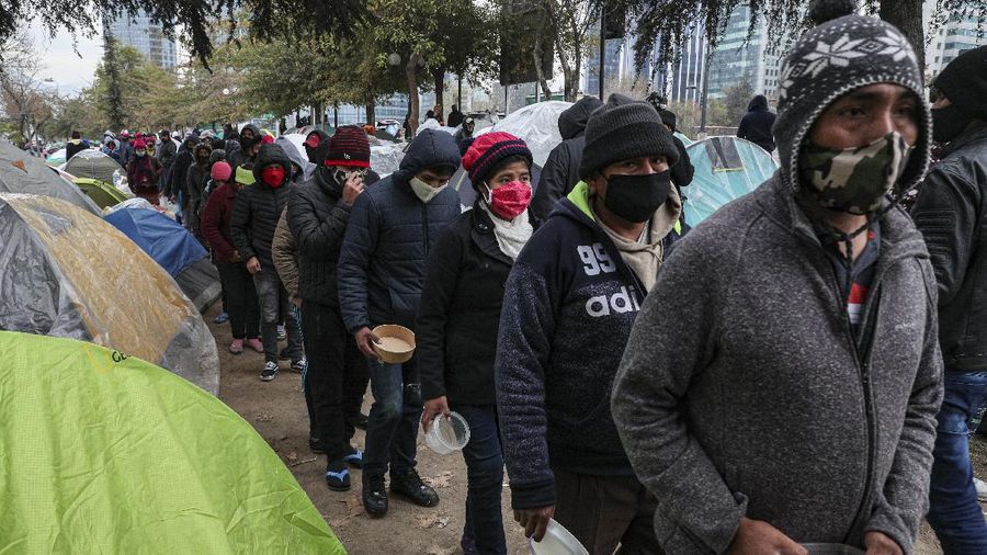 Para pekerja migran asal Peru membangun tenda di luar gedung konsulat Peru untuk menuntut repatriasi di tengah pandemi COVID-19 di Santiago, Chili. AP/Esteban Felix