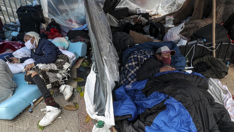 Para pekerja migran asal Peru membangun tenda di luar gedung konsulat Peru untuk menuntut repatriasi di tengah pandemi COVID-19 di Santiago, Chili. AP/Esteban Felix