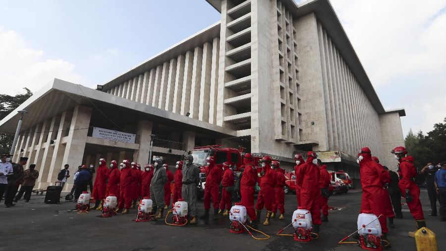 Seorang petugas pemadam kebakaran menyemprotkan desinfektan dalam upaya membantu mengekang penyebaran virus corona baru di Masjid Istiqlal di Jakarta. AP/Achmad Ibrahim