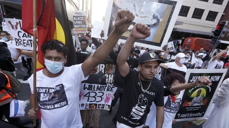 Protestors march in Sydney, Saturday, June 6, 2020, to support the cause of U.S. protests over the death of George Floyd. Black Lives Matter protests across Australia proceeded mostly peacefully as thousands of demonstrators in state capitals honored the memory of Floyd and protested the deaths of indigenous Australians in custody. (AP Photo/Rick Rycroft)