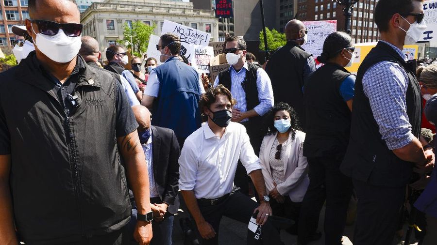 Prime Minister Justin Trudeau shakes hands with a participant who gave him a Black Lives Matter T-shirt as he takes part in an anti-racism protest on Parliament Hill during the coronavirus pandemic in Ottawa, Ontario, Friday, June 5, 2020. The death of George Floyd, a black man who died after he was restrained by Minneapolis police officers on May 25, has ignited protests in the U.S. and worldwide over racial injustice and police brutality. (Sean Kilpatrick/The Canadian Press via AP)