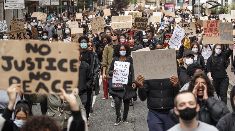 People take part in a Black Lives Matter protest rally in Manchester, England, Sunday, June 7, 2020, in response to the recent killing of George Floyd by police officers in Minneapolis, USA, that has led to protests in many countries and across the US. (Danny Lawson/PA via AP)
