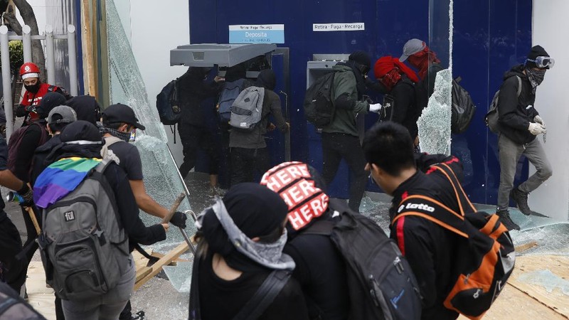 A line of police and anarchist protestors stare at each other from a distance after the demonstrators tore down barriers to enter pedestrian Madero street, which has been closed for months due to the coronavirus pandemic, during a march in Mexico City, Monday, June 8, 2020. (AP Photo/Rebecca Blackwell)