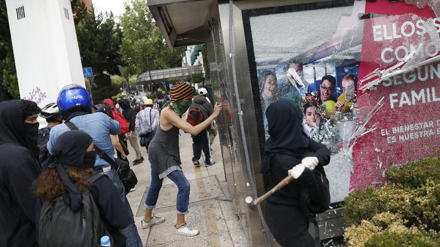A line of police and anarchist protestors stare at each other from a distance after the demonstrators tore down barriers to enter pedestrian Madero street, which has been closed for months due to the coronavirus pandemic, during a march in Mexico City, Monday, June 8, 2020. (AP Photo/Rebecca Blackwell)