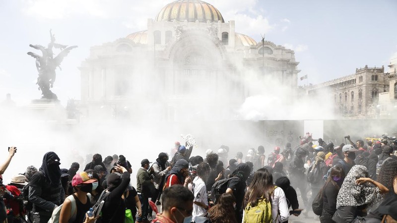 A line of police and anarchist protestors stare at each other from a distance after the demonstrators tore down barriers to enter pedestrian Madero street, which has been closed for months due to the coronavirus pandemic, during a march in Mexico City, Monday, June 8, 2020. (AP Photo/Rebecca Blackwell)