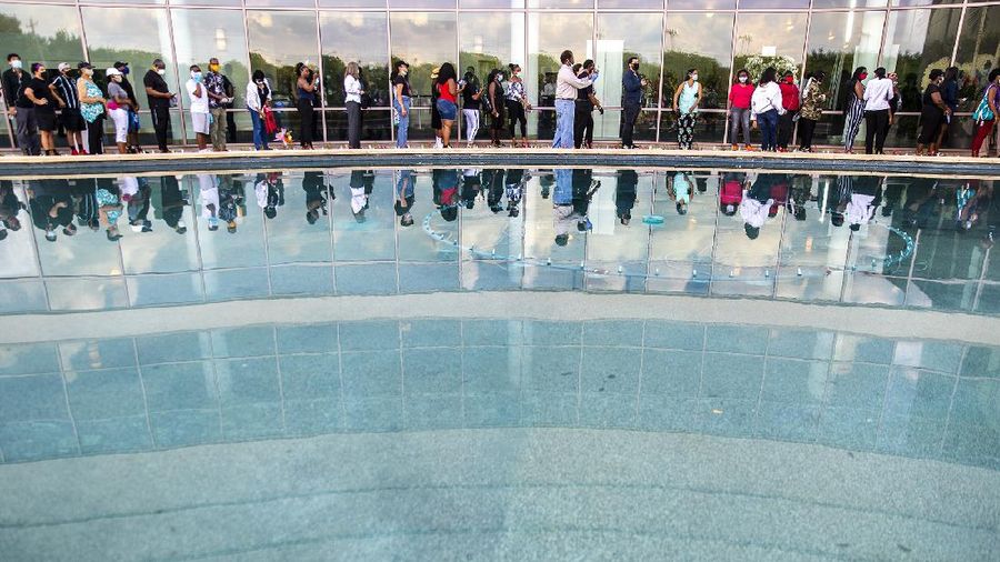 Mourners pass by the casket of George Floyd during a public visitation for Floyd at the Fountain of Praise church Monday, June 8, 2020, in Houston. (AP Photo/David J. Phillip, Pool)