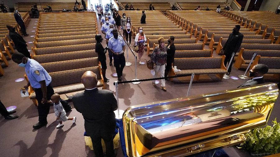 Mourners pass by the casket of George Floyd during a public visitation for Floyd at the Fountain of Praise church Monday, June 8, 2020, in Houston. (AP Photo/David J. Phillip, Pool)