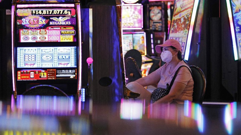 A man plays craps at the reopening of the Bellagio hotel and casino Thursday, June 4, 2020, in Las Vegas. Casinos in Nevada were allowed to reopen on Thursday for the first time after temporary closures as a precaution against the coronavirus. (AP Photo/John Locher)