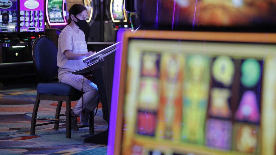 A man plays craps at the reopening of the Bellagio hotel and casino Thursday, June 4, 2020, in Las Vegas. Casinos in Nevada were allowed to reopen on Thursday for the first time after temporary closures as a precaution against the coronavirus. (AP Photo/John Locher)