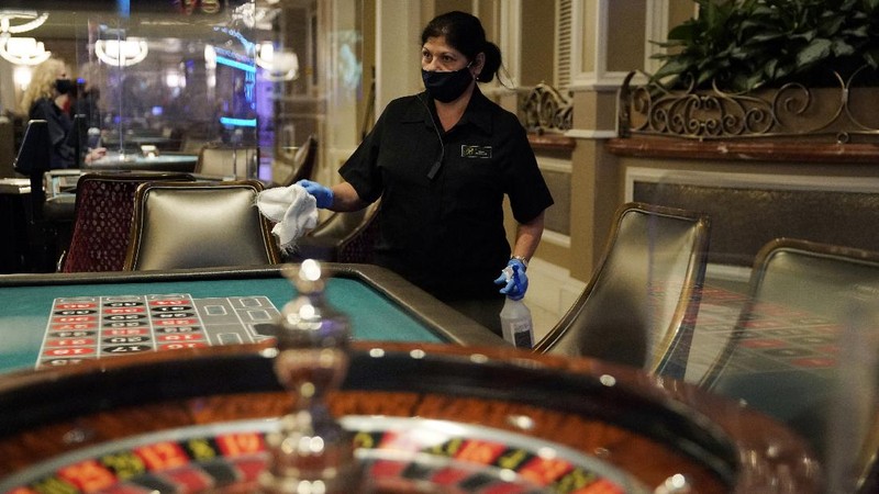 A man plays craps at the reopening of the Bellagio hotel and casino Thursday, June 4, 2020, in Las Vegas. Casinos in Nevada were allowed to reopen on Thursday for the first time after temporary closures as a precaution against the coronavirus. (AP Photo/John Locher)