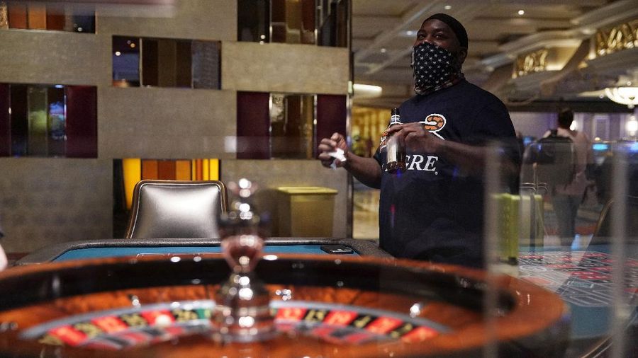 A man plays craps at the reopening of the Bellagio hotel and casino Thursday, June 4, 2020, in Las Vegas. Casinos in Nevada were allowed to reopen on Thursday for the first time after temporary closures as a precaution against the coronavirus. (AP Photo/John Locher)
