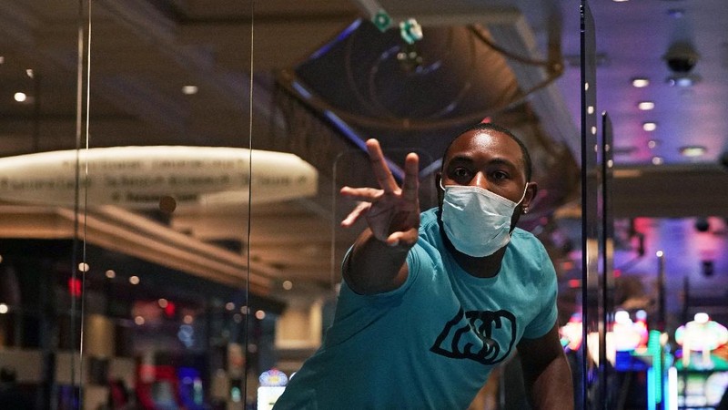 A man plays craps at the reopening of the Bellagio hotel and casino Thursday, June 4, 2020, in Las Vegas. Casinos in Nevada were allowed to reopen on Thursday for the first time after temporary closures as a precaution against the coronavirus. (AP Photo/John Locher)