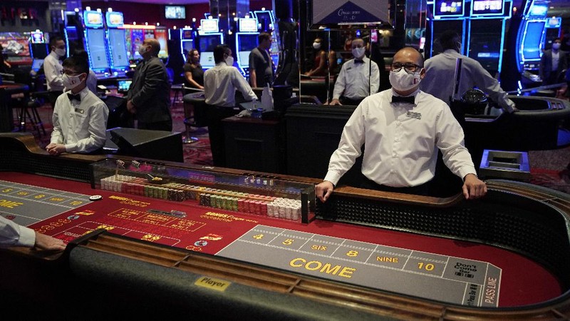 A man plays craps at the reopening of the Bellagio hotel and casino Thursday, June 4, 2020, in Las Vegas. Casinos in Nevada were allowed to reopen on Thursday for the first time after temporary closures as a precaution against the coronavirus. (AP Photo/John Locher)