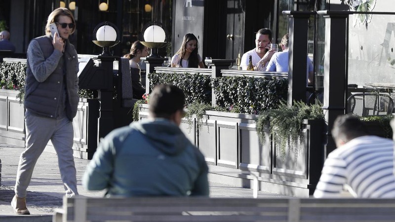 Pedestrians walk past a billboard featuring Prime Minister Jacinda Ardern with the word Aroha, meaning love, in Christchurch, New Zealand, Monday, June 8, 2020. New Zealand appears to have completely eradicated the coronavirus, at least for now, after health officials said Monday the last known infected person had recovered. (AP Photo/Mark Baker)