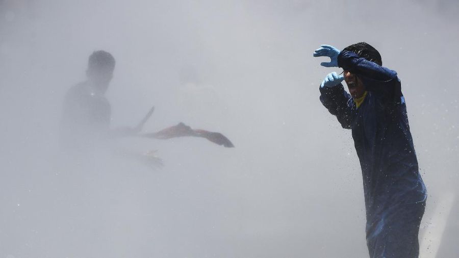 Nepalese police use water cannon to disperse youth who gathered for a protest near prime minister's residence demanding better handling of the COVID-19 pandemic in Kathmandu, Nepal, Thursday, June 11, 2020. About 1000 protesters had gathered demanding increased testing and alleging corruption by government officials while purchasing equipment and testing kits. (AP Photo/Niranjan Shrestha)