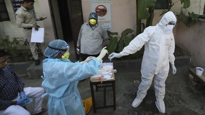 Wabah Virus Corona di India In this Wednesday, June 10, 2020 photo, a health worker transfers sample of a person from a swab test for COVID 19 in New Delhi, India. Two and a half months of nationwide lockdown kept numbers of infections relatively low in India. But with restrictions easing in recent weeks, cases have shot up, raising questions about whether authorities have done enough to avert catastrophe. Half of Delhi’s 8,200 hospital beds dedicated to COVID-19 patients are already full and officials are projecting more than half a million cases in the city alone by July 31. (AP Photo/Manish Swarup)