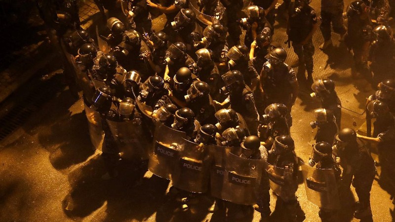 A police officer directs a water cannon to extinguish a shop that was set on fire by protesters during an anti-government protest in Beirut, Lebanon, early Friday, June 12, 2020. Lebanon's prime minister held an emergency Cabinet meeting Friday, hours after demonstrators shut roads across the country with burning tires in renewed nationwide protests spurred by a plunging national currency and economic crisis. (AP Photo/Hussein Malla)
