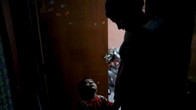 In this June 2, 2020 photo, parish assistant Natividad Benitez serves a hot drink outside a church, during a government-ordered lockdown to curb the spread of the new coronavirus, in the Villa 1-11-14 shanty town of Buenos Aires, Argentina. Since coronavirus came to Argentina, the priest who employs her has gone from serving 350 meals a day to 7000, feeding residents of the poor neighborhood where economic activity has all but stopped due to strict anti-virus measures.  (AP Photo/Natacha Pisarenko)