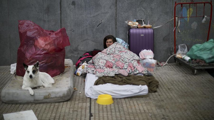 In this June 2, 2020 photo, parish assistant Natividad Benitez serves a hot drink outside a church, during a government-ordered lockdown to curb the spread of the new coronavirus, in the Villa 1-11-14 shanty town of Buenos Aires, Argentina. Since coronavirus came to Argentina, the priest who employs her has gone from serving 350 meals a day to 7000, feeding residents of the poor neighborhood where economic activity has all but stopped due to strict anti-virus measures.  (AP Photo/Natacha Pisarenko)