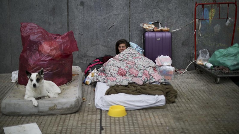In this June 2, 2020 photo, parish assistant Natividad Benitez serves a hot drink outside a church, during a government-ordered lockdown to curb the spread of the new coronavirus, in the Villa 1-11-14 shanty town of Buenos Aires, Argentina. Since coronavirus came to Argentina, the priest who employs her has gone from serving 350 meals a day to 7000, feeding residents of the poor neighborhood where economic activity has all but stopped due to strict anti-virus measures.  (AP Photo/Natacha Pisarenko)