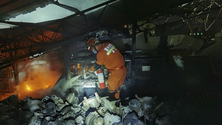 Firefighters look for victims in damaged buildings in the aftermath of a tanker truck explosion near a highway in Wenling in eastern China's Zhejiang province early Sunday, June 14, 2020. More than a dozen were killed and others injured after the tanker truck veered off the Shenyang-Haikou Expressway after the explosion. (Chinatopix via AP)