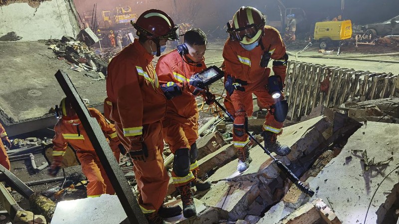 Firefighters look for victims in damaged buildings in the aftermath of a tanker truck explosion near a highway in Wenling in eastern China's Zhejiang province early Sunday, June 14, 2020. More than a dozen were killed and others injured after the tanker truck veered off the Shenyang-Haikou Expressway after the explosion. (Chinatopix via AP)