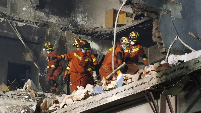 Firefighters look for victims in damaged buildings in the aftermath of a tanker truck explosion near a highway in Wenling in eastern China's Zhejiang province early Sunday, June 14, 2020. More than a dozen were killed and others injured after the tanker truck veered off the Shenyang-Haikou Expressway after the explosion. (Chinatopix via AP)