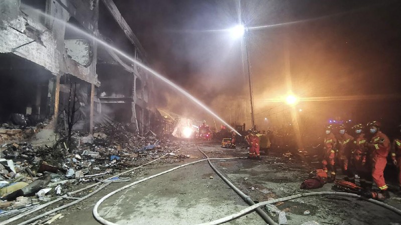Firefighters look for victims in damaged buildings in the aftermath of a tanker truck explosion near a highway in Wenling in eastern China's Zhejiang province early Sunday, June 14, 2020. More than a dozen were killed and others injured after the tanker truck veered off the Shenyang-Haikou Expressway after the explosion. (Chinatopix via AP)