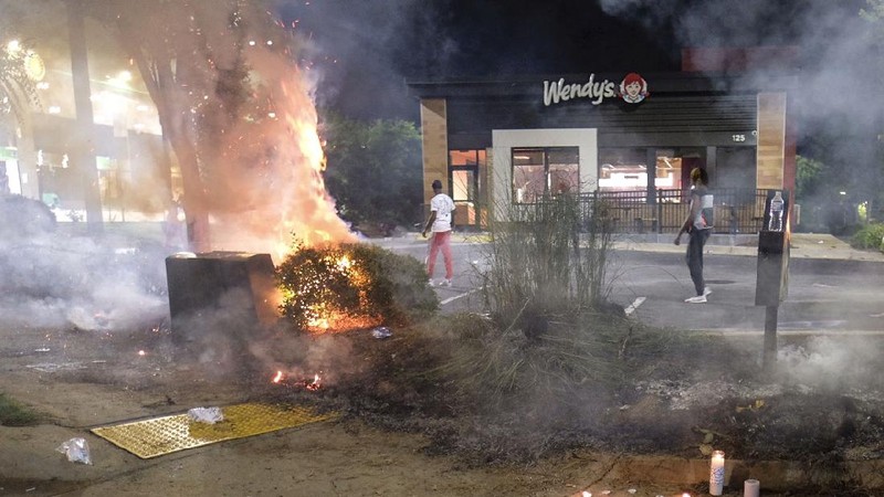 Police attempt to control protestors outside a Wendy's restaurant Saturday, June 13, 2020 in Atlanta. Georgia authorities said Saturday a man was shot and killed in a late night struggle with Atlanta police outside a fast food restaurant after he failed a field sobriety test and resisted arrest. (Ben Gray/Atlanta Journal-Constitution via AP)