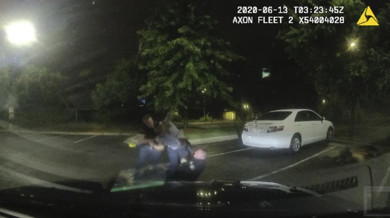 This screen grab taken from body camera video provided by the Atlanta Police Department shows Rayshard Brooks speaking with Officer Garrett Rolfe in the parking lot of a Wendy's restaurant, late Friday, June 12, 2020, in Atlanta. Rolfe has been fired following the fatal shooting of Brooks and a second officer has been placed on administrative duty. (Atlanta Police Department via AP)