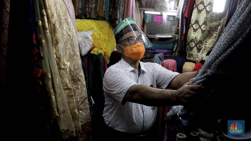 Suasana Pasar Perumnas Klender, Jakarta Timur, Senin 15/6.  Untuk mencegah masifnya penyebaran Covid-19 di pasar-pasar tradisional Jakarta, PD Pasar Jaya mengambil beberapa kebijakan diantaranya menutup pasar dan menerapkan aturan ganjil-genap. Salah satunya di pasar Perumnas Klender. Aturan pasar ganjil genap mulai berlaku hari ini. Praktik ganjil-genap di pasar itu  berlaku sesuai dengan nomor kios. Apabila tanggal genap, maka kios yang buka hanya bernomor genap, begitu sebaliknya. Terlihat sejumlah pedagang mentaati aturan wajib menggunakan face shield dan masker ketika berjualan.  Untuk pembeli wajib mengenakan masker. Pasar hanya beroperasi sejak pukul 06.00 WIB hingga pukul 14.00 WIB. Salah satu pedagang kios baju anak dan muslim Guswandi mengatakan adanya peraturan ini membuat  penghasilan berkurang. 