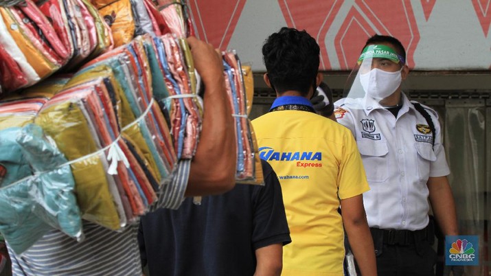 Pasar Tanah Abang (CNBC Indonesia/Tri Susilo) Suasana Pasar Tanah Abang resmi dibuka kembali hari ini setelah sebelumnya tutup karena pembatasan sosial berskala besar (PSBB) DKI Jakarta. 15/6/20, CNBC Indonesia/Tri Susilo
Pantauan CNBC Indonesia di Ruko Blok B Pasar Tanah Abang, Jakarta Pusat, Senin (15/6/2020), kawasan ruko ini didominasi oleh pedagang baju, kain dan kerudung. Setiap pengunjung berjalan, pedagang pun menjajakan barang jualannya.
Sebelum memasuki pasar pengunjung dicek suhu oleh dinas kesehatan setempat dan pihak pengelola mal sudah menyediakan tempat cuci tangan di setiap Blok pintu masuk pasar.
Terdapat masyarakat dan pedagang yang sedang melalukan transaksi jual-beli. Mereka bertransaksi menggunakan masker. Namun, hanya sedikit pedagang yang menggunakan face shield.
Mayoritas pengunjung membeli barang dalam jumlah yang banyak. Bahkan, tak jarang pengunjung datang dengan membawa trolly lipat untuk memudahkannya membawa barang.
Seperti diketahui, Perumda Pasar Jaya menerapkan sistem ganjil-genap di pasar-pasar yang dikelolanya. Skema ganjil-genap di pasar berlaku sesuai dengan nomor kios, misalnya apabila tanggal genap, maka kios yang bukan hanya bernomor genap.
Direktur Utama Perumda (PD) Pasar Jaya Arief Nasrudin mengatakan aturan ganjil-genap di pasar di wilayah DKI Jakarta akan berlaku pada 15 Juni 2020. Aturan tersebut diberlakukan untuk mencegah semakin masifnya penularan Virus Corona (COVID-19) di pasar. (CNBC Indonesia/Tri Susilo)