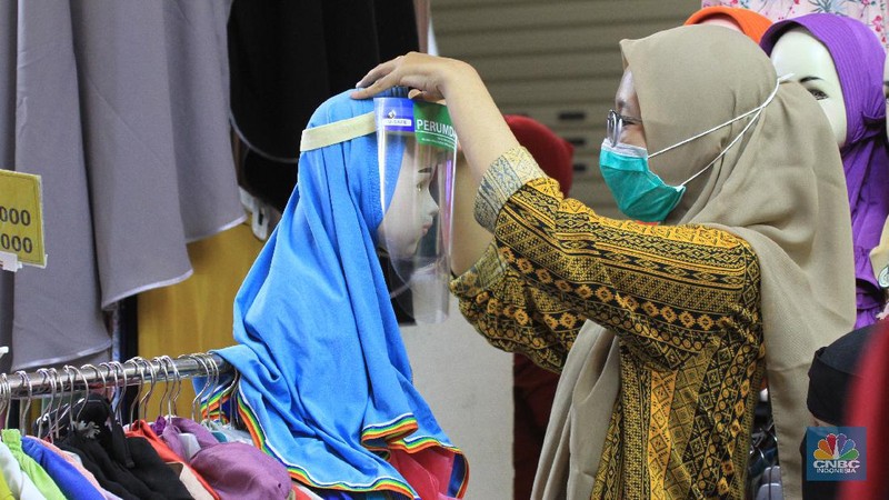 Suasana Pasar Tanah Abang resmi dibuka kembali hari ini setelah sebelumnya tutup karena pembatasan sosial berskala besar (PSBB) DKI Jakarta. 15/6/20, CNBC Indonesia/Tri Susilo
Pantauan CNBC Indonesia di Ruko Blok B Pasar Tanah Abang, Jakarta Pusat, Senin (15/6/2020), kawasan ruko ini didominasi oleh pedagang baju, kain dan kerudung. Setiap pengunjung berjalan, pedagang pun menjajakan barang jualannya.  

Sebelum memasuki pasar pengunjung dicek suhu oleh dinas kesehatan setempat dan pihak pengelola mal sudah menyediakan tempat cuci tangan di setiap Blok pintu masuk pasar.

Terdapat masyarakat dan pedagang yang sedang melalukan transaksi jual-beli. Mereka bertransaksi menggunakan masker. Namun, hanya sedikit pedagang yang menggunakan face shield.

Mayoritas pengunjung membeli barang dalam jumlah yang banyak. Bahkan, tak jarang pengunjung datang dengan membawa trolly lipat untuk memudahkannya membawa barang. 

Seperti diketahui, Perumda Pasar Jaya menerapkan sistem ganjil-genap di pasar-pasar yang dikelolanya. Skema ganjil-genap di pasar berlaku sesuai dengan nomor kios, misalnya apabila tanggal genap, maka kios yang bukan hanya bernomor genap.

Direktur Utama Perumda (PD) Pasar Jaya Arief Nasrudin mengatakan aturan ganjil-genap di pasar di wilayah DKI Jakarta akan berlaku pada 15 Juni 2020. Aturan tersebut diberlakukan untuk mencegah semakin masifnya penularan Virus Corona (COVID-19) di pasar. (CNBC Indonesia/Tri Susilo)