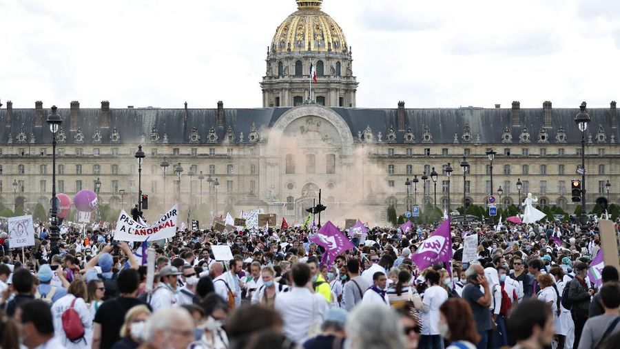 Hospital workers march during a demonstration, Tuesday, June 16, 2020 in Paris. French hospital workers and others are protesting in cities around the country to demand better pay and more investment in France's public hospital system, which is considered among the world's best but struggled to handle a flux of virus patients after years of cost cuts. France has seen nearly 30,000 virus deaths. (AP Photo/Thibault Camus)