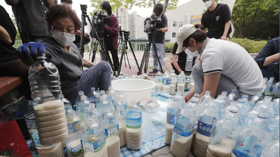 North Korean defector Park Jung-oh arranges plastic bottles with rice and face masks to send them toward North Korea by balloons, in Seoul, South Korea, Thursday, June 18, 2020. The anti-North Korea activist made preparations to push ahead his plan to send his propaganda leaflets and bottles of rice tied to balloons over the border. (AP Photo/Ahn Young-joon)