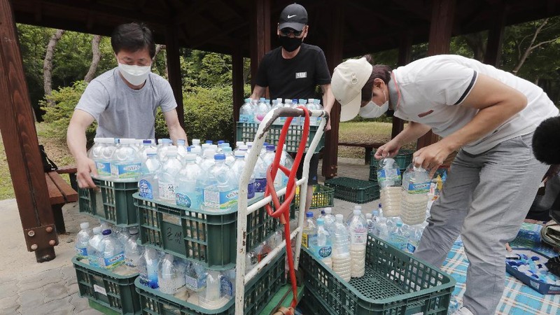 North Korean defector Park Jung-oh arranges plastic bottles with rice and face masks to send them toward North Korea by balloons, in Seoul, South Korea, Thursday, June 18, 2020. The anti-North Korea activist made preparations to push ahead his plan to send his propaganda leaflets and bottles of rice tied to balloons over the border. (AP Photo/Ahn Young-joon)