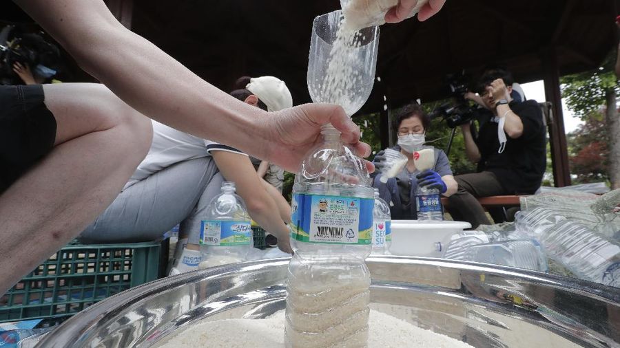 North Korean defector Park Jung-oh arranges plastic bottles with rice and face masks to send them toward North Korea by balloons, in Seoul, South Korea, Thursday, June 18, 2020. The anti-North Korea activist made preparations to push ahead his plan to send his propaganda leaflets and bottles of rice tied to balloons over the border. (AP Photo/Ahn Young-joon)
