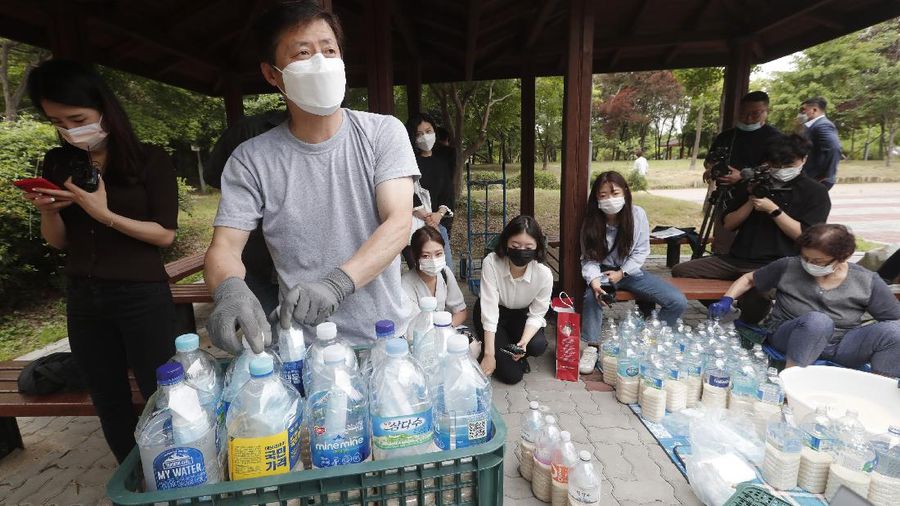 North Korean defector Park Jung-oh arranges plastic bottles with rice and face masks to send them toward North Korea by balloons, in Seoul, South Korea, Thursday, June 18, 2020. The anti-North Korea activist made preparations to push ahead his plan to send his propaganda leaflets and bottles of rice tied to balloons over the border. (AP Photo/Ahn Young-joon)