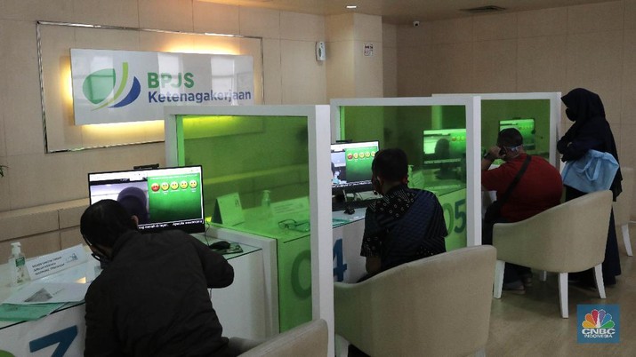 Layanan BPJS Ketenagakerjaan (CNBC Indonesia/ Muhammad Sabki) Peserta BP Jamsostek konsultasi layanan tanpa kontak fisik dengan virtual di Kantor Cabang BPJS Ketenagakerjaan Cilandak, Kamis (18/6/2020). Layanan secara virtual ini merupakan penerapan sesuai dengan protokol kesehatan tanpa harus kontak langsung antara petugas dan peserta BP Jamsostek dalam rangka mencegah penularan COVID-19. Kepala Kantor Cabang Puspitaningsih mengatakan adanya layanan konsultasi tanpa kontak fisik ini di Cabang Cilandak ini disesuaikan dengan aturan protokol kesehatan dan untuk memutus penyebaran Covid-19. Kantor cabang ini menyediakan skat-skat yang dilengkapi layar monitor yang terhubung dengan petugas secara video conference untuk kebutuhan komunikasi dan verifikasi data.