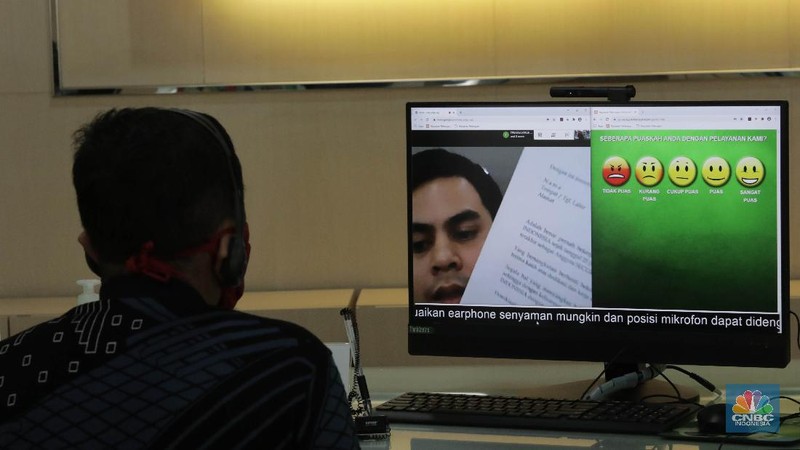 Peserta BP Jamsostek konsultasi layanan tanpa kontak fisik dengan virtual di Kantor Cabang BPJS Ketenagakerjaan Cilandak, Kamis (18/6/2020). Layanan secara virtual ini merupakan penerapan sesuai dengan protokol kesehatan tanpa harus kontak langsung antara petugas dan peserta BP Jamsostek dalam rangka mencegah penularan COVID-19. Kepala Kantor Cabang Puspitaningsih mengatakan adanya layanan konsultasi tanpa kontak fisik ini di Cabang Cilandak ini disesuaikan dengan aturan protokol kesehatan dan untuk memutus penyebaran Covid-19.  Kantor cabang ini menyediakan skat-skat yang dilengkapi layar monitor yang terhubung dengan petugas secara video conference untuk kebutuhan komunikasi dan verifikasi data. 