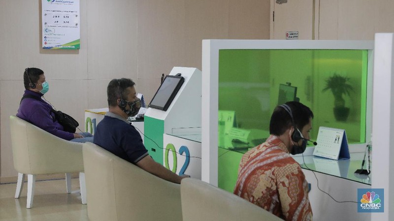 Peserta BP Jamsostek konsultasi layanan tanpa kontak fisik dengan virtual di Kantor Cabang BPJS Ketenagakerjaan Cilandak, Kamis (18/6/2020). Layanan secara virtual ini merupakan penerapan sesuai dengan protokol kesehatan tanpa harus kontak langsung antara petugas dan peserta BP Jamsostek dalam rangka mencegah penularan COVID-19. Kepala Kantor Cabang Puspitaningsih mengatakan adanya layanan konsultasi tanpa kontak fisik ini di Cabang Cilandak ini disesuaikan dengan aturan protokol kesehatan dan untuk memutus penyebaran Covid-19.  Kantor cabang ini menyediakan skat-skat yang dilengkapi layar monitor yang terhubung dengan petugas secara video conference untuk kebutuhan komunikasi dan verifikasi data. 