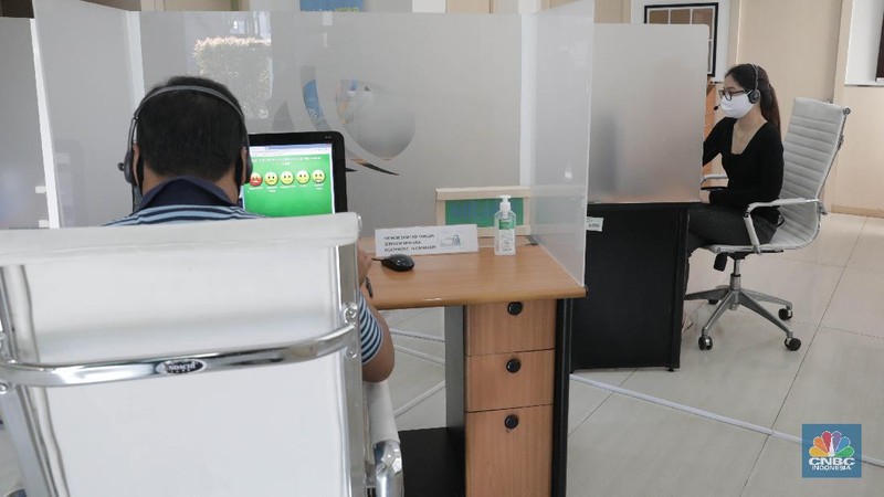 Peserta BP Jamsostek konsultasi layanan tanpa kontak fisik dengan virtual di Kantor Cabang BPJS Ketenagakerjaan Cilandak, Kamis (18/6/2020). Layanan secara virtual ini merupakan penerapan sesuai dengan protokol kesehatan tanpa harus kontak langsung antara petugas dan peserta BP Jamsostek dalam rangka mencegah penularan COVID-19. Kepala Kantor Cabang Puspitaningsih mengatakan adanya layanan konsultasi tanpa kontak fisik ini di Cabang Cilandak ini disesuaikan dengan aturan protokol kesehatan dan untuk memutus penyebaran Covid-19.  Kantor cabang ini menyediakan skat-skat yang dilengkapi layar monitor yang terhubung dengan petugas secara video conference untuk kebutuhan komunikasi dan verifikasi data. 