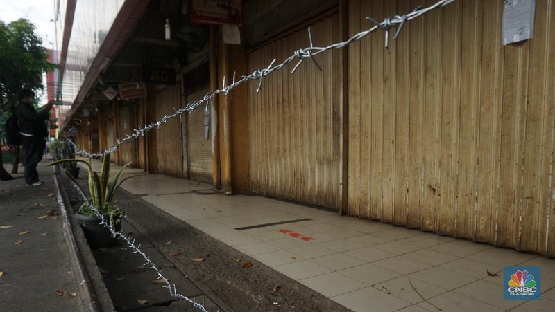 Suasana Pasar Jaya, Kebayoran Lama Jakarta selatan yang ditutup akibat adanya  pedagang  yang terinveksi COVID-19. 18/6/20, CNBC Indonesia/ Tri Susilo

Sebanyak 14 pedagang di Pasar Kebayoran Lama, Jakarta Selatan, dinyatakan terinfeksi positif virus Corona (COVID-19). Akibatnya, pasar tersebut akan ditutup selama 3 hari ke depan.
Informasi penutupan sementara Pasar Kebayoran Lama akibat adanya pedagang positif Corona dibenarkan oleh Wakil Camat Kebayoran Lama, Sidik Rayanta. Sidik menyebut kios yang ada di pasar ini akan ditutup mulai hari kamis ini.   

Dari data yang terima, sebanyak 59 pedagang di Pasar Kebayoran Lama sebelumnya telah menjalani swab test. Hasilnya, ada 14 pedagang dikonfirmasi positif Corona.

Dari pantauan CNBC Indonesia kawat berduri dan garis policeline juga terpasang diarea pasar jaya ini agar para masyarakat tidak memasuki pasar.

Disamping pasar jaya (pasar tradisional tampak buka dan para pedagang tetap melayani pembeli seperti biasa. 

Pengguna sepeda motor yang melewati pasar kebayoran lama agar memakai masker sepertinya, terlihat pedagang masker juga ada dilokasi pasar jaya Kebayoran Lama. 

Petugas keamanan pasar yang berjaga dilokasi terlihat menempelkan selembaran himbauan kepada masyarakat untuk tidak datang ke pasar kebayoran lama terlebih dahulu.  (CNBC Indonesia/ Tri Susilo)
