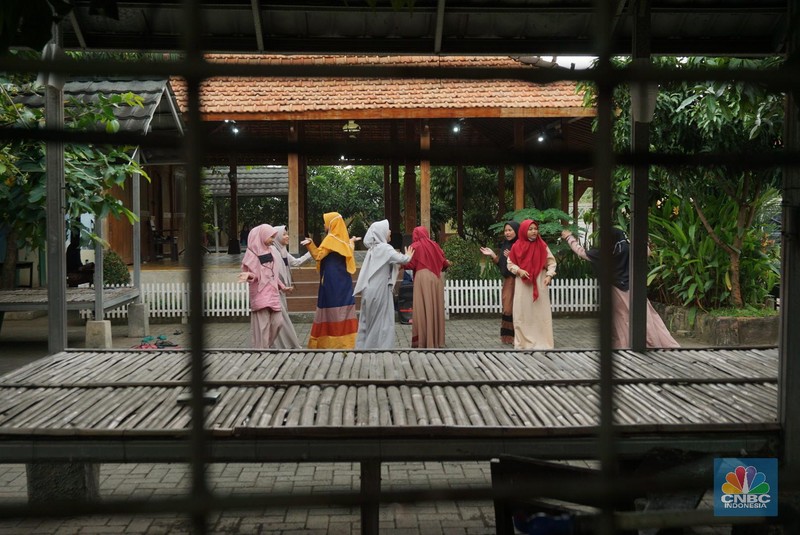 Suasana Pesantren An-Nuqthah, Tangerang Banten, sejumlah santri kembali berdatangan usai belajar di rumah selama pandemi corona. 18/6/20. CNBC Indonesia/Tri Susilo Para santri juga harus mengenakan masker walaupun sudah berada di dalam pesantren. Pemulangan santri ke pesantren dilakukan selama beberapa tahap dalam satu minggu. Ini dilakukan guna menghindari penumpukan orang dalam satu waktu. Pada tahap awal, santri yang kembali baru sekira 15 persen dari total 1.500 santri. Sementara, sebagian orangtua masih khawatir akan penularan virus corona di dalam pesantren. Karena itu mereka membekali buah hatinya dengan cairan pembersih tangan, vitamin dan persediaan masker. Sementara pengelola pesantren menyebut, kebijakan membuka kembali aktifitas belajar tatap muka karena pihaknya merasa sudah sanggup menerapkan protokol kesehatan di dalam pesantren. Guna penerapan protokol kesehatan, pihak pengelola melakukan sterilisasi lingkungan pesantren secara rutin, menata ulang kamar-kamar tidur para santri, dan menjaga jarak antar individu, baik dalam setiap kegiatan belajar mengajar maupun ibadah. Pantauan CNBC Indonesia Dilapangan para santri yang melakukan ibadah harus tetap jaga jarak didalam masjid. Santri yang balik ke pesantren belum semuanya berdatangan, kemungkinan gelombang kedua akan datang pada bulan Juli 2020 mendatang. (CNBC Indonesia/ Tri Susilo)