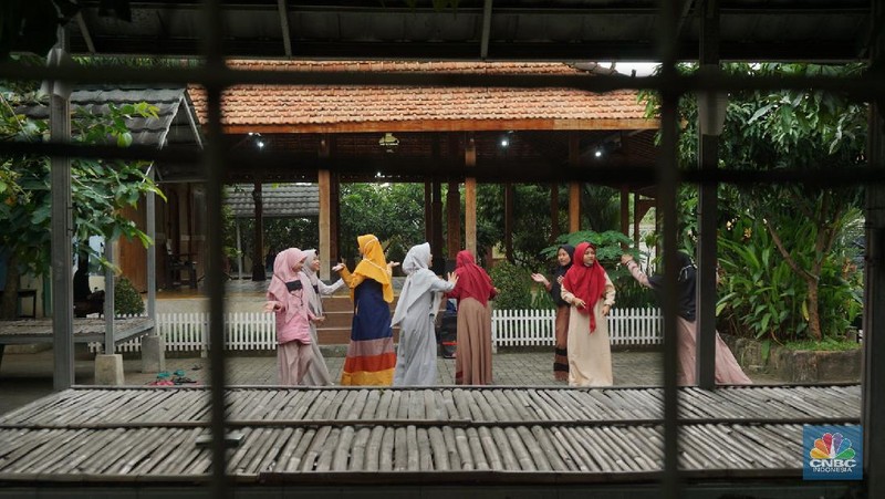 Suasana Pesantren An-Nuqthah, Tangerang Banten, sejumlah santri kembali berdatangan usai belajar di rumah selama pandemi corona. 18/6/20. CNBC Indonesia/Tri Susilo Para santri juga harus mengenakan masker walaupun sudah berada di dalam pesantren. Pemulangan santri ke pesantren dilakukan selama beberapa tahap dalam satu minggu. Ini dilakukan guna menghindari penumpukan orang dalam satu waktu. Pada tahap awal, santri yang kembali baru sekira 15 persen dari total 1.500 santri. Sementara, sebagian orangtua masih khawatir akan penularan virus corona di dalam pesantren. Karena itu mereka membekali buah hatinya dengan cairan pembersih tangan, vitamin dan persediaan masker. Sementara pengelola pesantren menyebut, kebijakan membuka kembali aktifitas belajar tatap muka karena pihaknya merasa sudah sanggup menerapkan protokol kesehatan di dalam pesantren. Guna penerapan protokol kesehatan, pihak pengelola melakukan sterilisasi lingkungan pesantren secara rutin, menata ulang kamar-kamar tidur para santri, dan menjaga jarak antar individu, baik dalam setiap kegiatan belajar mengajar maupun ibadah. Pantauan CNBC Indonesia Dilapangan para santri yang melakukan ibadah harus tetap jaga jarak didalam masjid. Santri yang balik ke pesantren belum semuanya berdatangan, kemungkinan gelombang kedua akan datang pada bulan Juli 2020 mendatang. (CNBC Indonesia/ Tri Susilo)